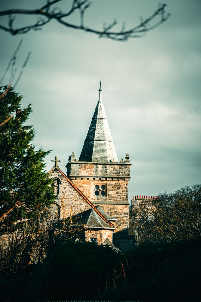 A captivating view of a historic church tower in Scotland, highlighting its gothic architecture.